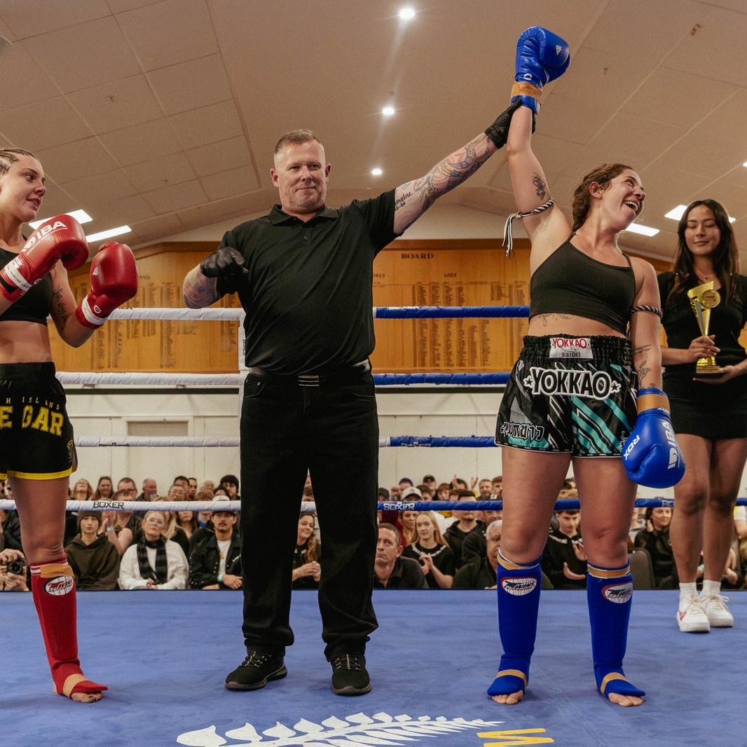 Jules Vassalos having her hand raised after a Muay Thai bout