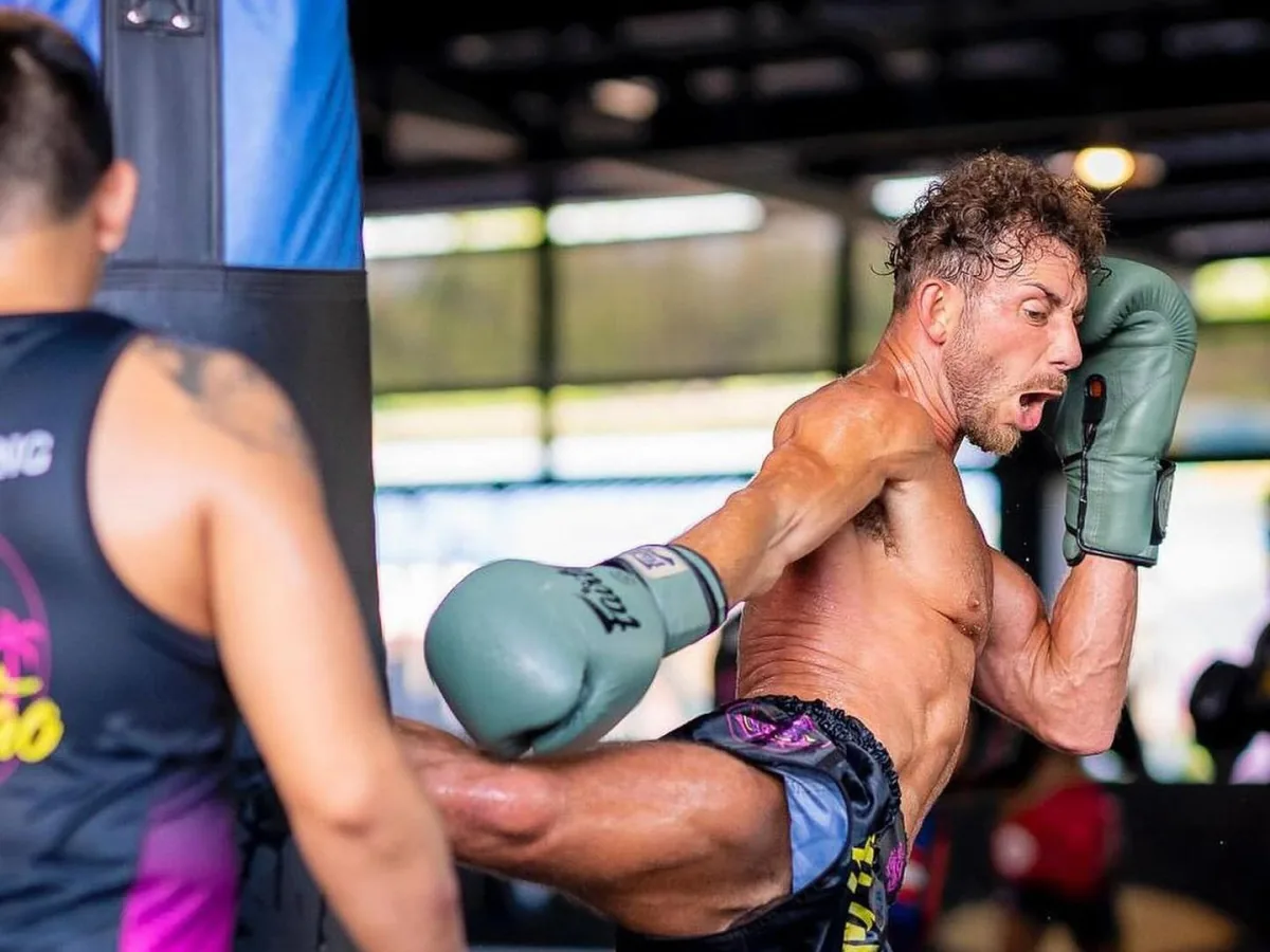 Charlie Charalambides throwing a kick during Muay Thai pad training